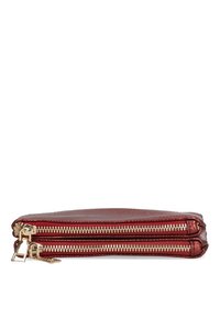 Cartera de cuero rojo con dos cremalleras doradas. Diseño plano, superficie texturizada, forma compacta. Los tiradores de las cremalleras son metálicos y funcionales.