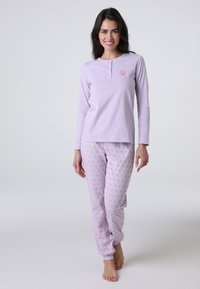 Top viola chiaro a maniche lunghe con scollo henley, abbinato a pantaloni viola chiaro con piccole pois rosa. Tessuto morbido, vestibilità casual.
