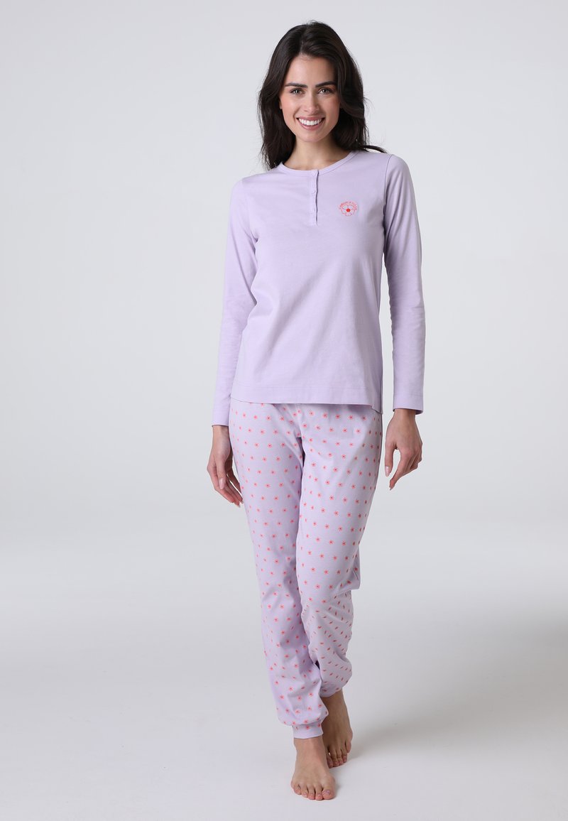 Top viola chiaro a maniche lunghe con scollo henley, abbinato a pantaloni viola chiaro con piccole pois rosa. Tessuto morbido, vestibilità casual.