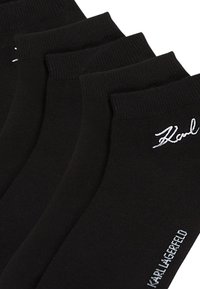 Calcetines de algodón negros con textura acanalada, que presentan los logotipos en blanco "Karl" y "Karl Lagerfeld" en los puños y los laterales. Conjunto de múltiples pares.