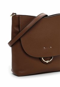 Borsa a tracolla in pelle marrone con chiusura a patta, dettaglio a cerchio in tonalità oro e tracolla regolabile su sfondo bianco.