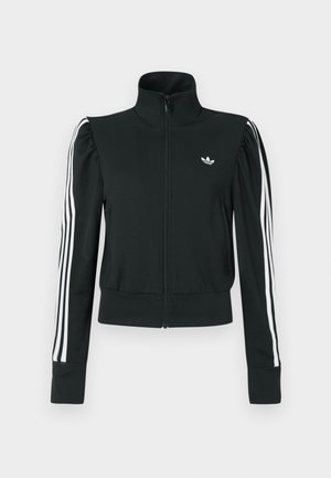 Giacca nera con zip, collo alto, pieghe sulle spalle e design a tre strisce bianche sulle maniche. Presenta un piccolo logo bianco sul petto.