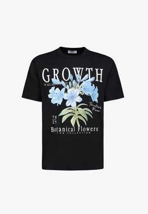 Schwarzes Baumwoll-T-Shirt mit einem vorderen Grafikdesign von blauen Blumen, dem Text "WACHSTUM IST ÜBERALL UM DICH HERUM" und Designelementen wie botanischen Details.