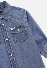 Jasnoniebieska koszula dżinsowa z klasycznym kołnierzykiem, dwoma kieszeniami na piersi, z zatrzaskami i metką "GUESS" na lewej kieszeni. Krótkie rękawy.