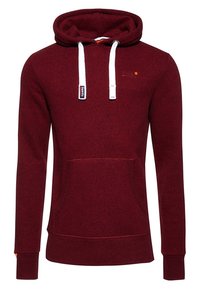 Sudadera burdeos hecha de tela texturizada, con un bolsillo tipo canguro, cordones blancos y puños y dobladillo acanalados. Incluye un sencillo detalle de logo.