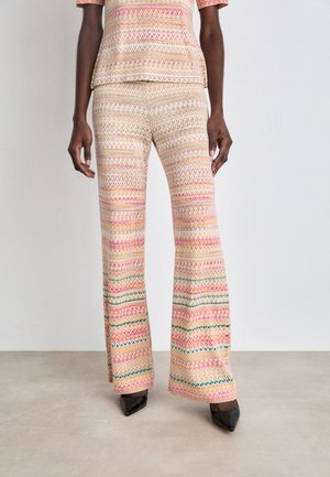 Multicolored patterned flared pants featuring zigzag designs in pink, cream, and green. Made from lightweight fabric with a smooth texture.