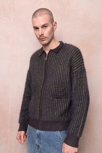 Mīkstas, svītrainas, ar rāvējslēdzēju aizdarāma jaka tumši zilās un olīvu zaļās krāsās. Ar apkakli, ribinātām piedurknēm un priekšējo kabatu. Mīksta tekstūra.