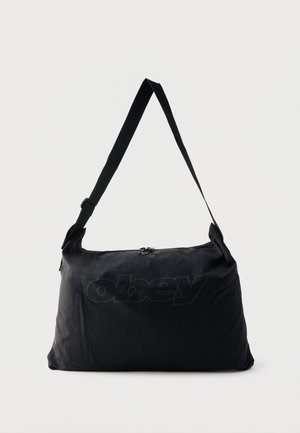 Mustast nailonist õlakott reguleeritava rihmaga, esiküljel peenelt reljeefse "obey" logoga, peamine lukuga avanev osakond.