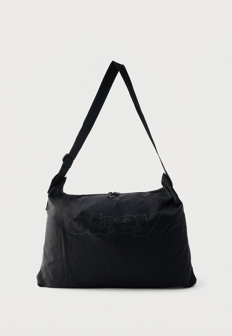 Μαύρη ώμου τσάντα από νάιλον με ρυθμιζόμενο ιμάντα και διακριτικό ανάγλυφο λογότυπο "obey" στο μπροστινό μέρος, κύριο διαμέρισμα με φερμουάρ.