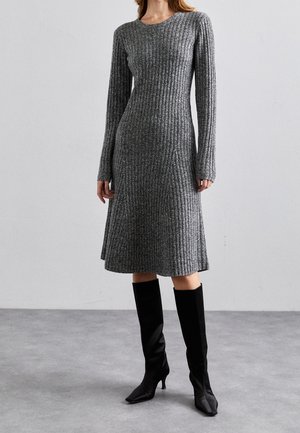 Robe en tricot côtelé gris avec des manches longues, coupe A-line et col rond ; assortie à des bottes noires à talons jusqu'aux genoux.