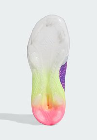 Semelle de chaussure de football dotée d'un design translucide avec un dégradé allant du jaune au rose, une grip texturé et des crampons placés de manière stratégique.