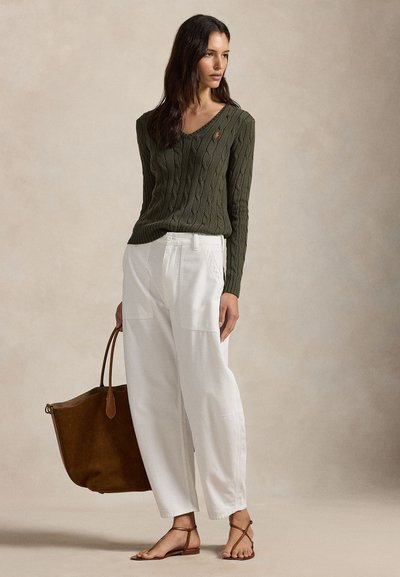 Oliivinvihreä, palmikkoneulottu V-pääntie neule, yhdistetty valkoisiin korkeavyötäröisiin housuihin. Ruskea olkalaukku ja ruskeat remmisandaalit täydentävät asun.