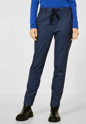 Pantalons de jogging bleu marine avec un motif texturé, taille élastique, cordon de serrage ajustable et jambes fuselées, assortis à des bottines noires.