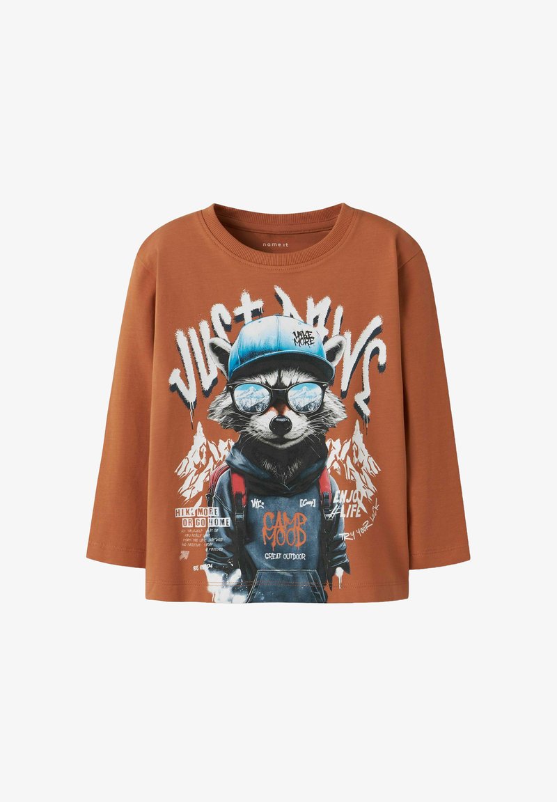 Braunes langärmliges T-Shirt mit einem Waschbär-Design in Sonnenbrille und blauer Mütze, verziert mit Text und Berg-Hintergründen. Weicher Stoff.