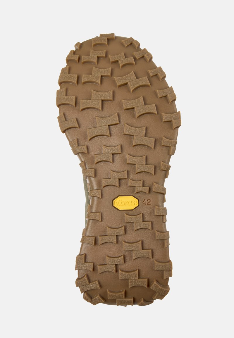 Brun gummisål med dybe riller for godt fodfæste, med Vibram-logo og størrelse 42. Tekstureret overflade med asymmetrisk mønster.