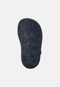 Laidan navy-kengän pohja, jossa on eläinprinttejä ja brändinimi "Camper" kohokuvioituna.