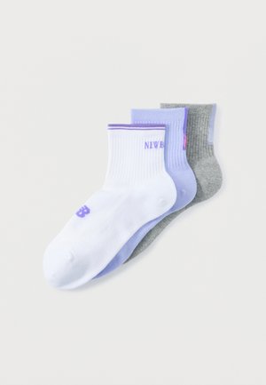 Három bokazokni fehér, levendula és szürke színekben, bordázott mandzsettákkal és finom hímzett felirattal egymásra helyezve.