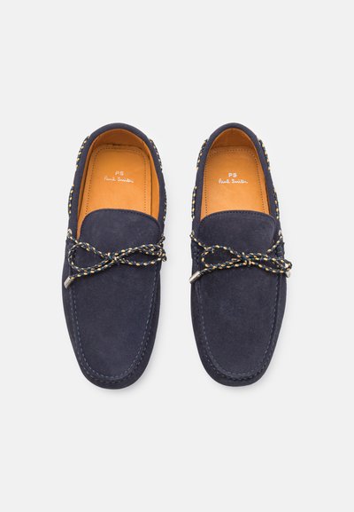Marineblå ruskinds loafers med rund tå, dekorative flettede snørebånd og kontrast-syninger. Brun læderforing og polstret indersål.