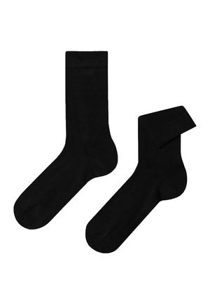 Calzini neri in cotone con una texture liscia, dotati di un classico risvolto a coste e una forma standard. Un calzino è piegato.