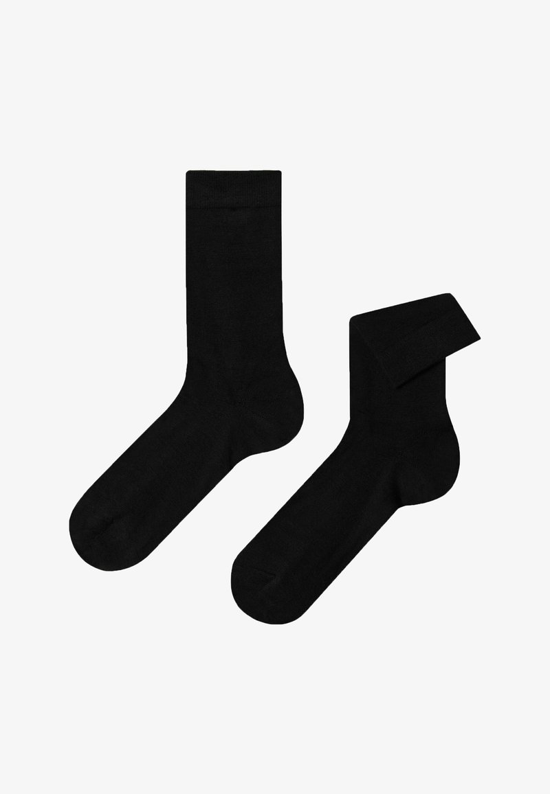 Schwarze Baumwollsocken mit glatter Textur, ausgestattet mit einem klassischen gerippten Bündchen und einer standardmäßigen Form. Eine Socke ist gefaltet.