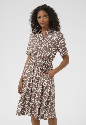 Brown and white printed wrap dress with short sleeves, button front, tie waist, and side pockets; made from lightweight, smooth fabric.