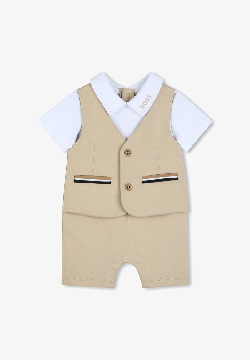 Beige korte overall met witte kraag en mouwen. Heeft twee voorzakken, twee knopen en gestreepte accenten bij de zakken.