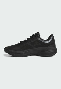 Baskets de sport noires avec une tige en maille, semelle en caoutchouc texturé, col rembourré et accents réfléchissants sur les côtés.