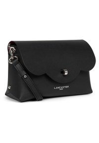 Clutch in pelle nera con patta scallopata, hardware in argento e tracolla regolabile. Presenta il logo impresso in bianco sul davanti.