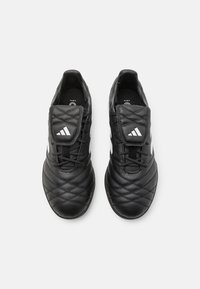Scarpe da calcio nere con texture trapuntata, design con lacci e linguetta imbottita. Presentano dettagli con logo bianco e una tomaia sintetica resistente.