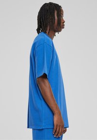 Blå bomulls oversized t-skjorte med korte ermer, rund hals og avslappet passform, med en jevn tekstur og minimale sømmer.