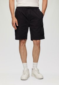 Shorts cargo noirs avec une taille élastique, un cordon de serrage et des poches latérales. Fabriqués en tissu léger, adaptés pour un port décontracté.