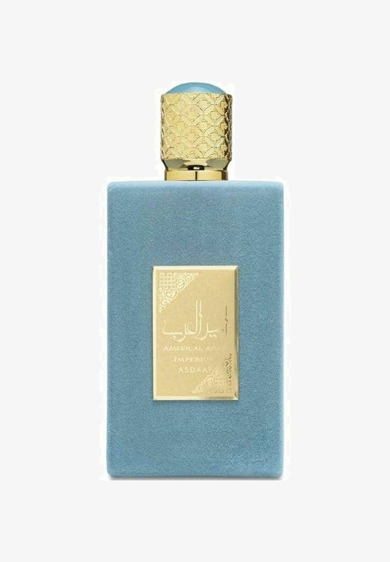 Blå sammetsrektangulär parfymflaska med ett texturerat gyllene lock. Har en gyllene etikett med intrikata mönster och arabiska tecken.