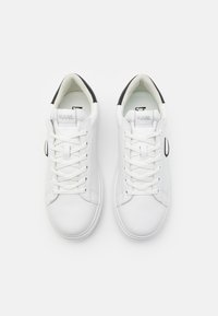Sneakers bianchi in pelle con chiusura a lacci, accentuazione nera sul tallone, texture liscia e etichetta con logo sulla linguetta. Design a punta rotonda.