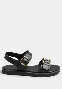 Mustat sandaalit teksturoiduilla nahkaremmeillä, joissa on kultasävyiset soljet, litteä pohja ja avonainen kantapää, mikä tarjoaa helppokäyttöisyyttä ja mukavuutta.