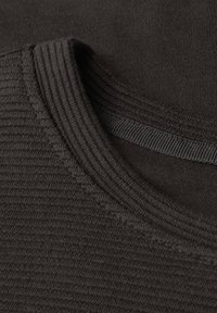 Tessuto di t-shirt marrone scuro, con un colletto a coste testurizzato e un corpo liscio. Dettagli di cucitura discreti visibili lungo i bordi.