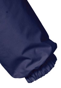 Mörkblått vattentåligt tyg med en mjuk textur, med ärmar som har elastiska manchetter. Synlig sömnad ger hållbarhet.