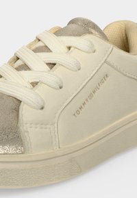 Κοντινή λήψη από λευκό-creme και μπεζ sneaker Tommy Hilfiger με λευκά κορδόνια και υφασμένο πάτο.