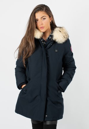 Parka marine avec capuche en fausse fourrure, boutons sur le devant, poches latérales et doublure à motifs. Longueur mi-cuisse, isolée pour la chaleur.