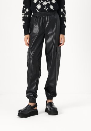 Zwarte faux leren joggers met een elastische tailleband en cuffs, voorzien van zijzakken en een gladde, glanzende textuur.