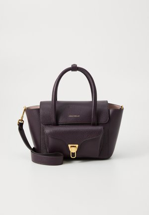Sac à main en cuir violet avec un design structuré, des poignées supérieures, une bandoulière détachable et des accents en matériel doré. Fermeture à rabat avec détail du logo.