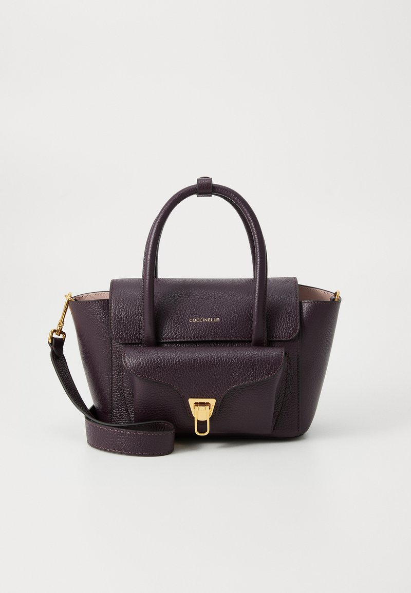 Sac à main en cuir violet avec un design structuré, des poignées supérieures, une bandoulière détachable et des accents en matériel doré. Fermeture à rabat avec détail du logo.