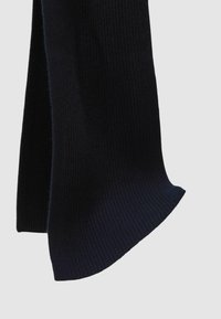 Bufanda de canalé en azul marino oscuro con una textura suave, que presenta un borde liso y un diseño que cae con gracia. Hecha de un tejido cálido y elástico.