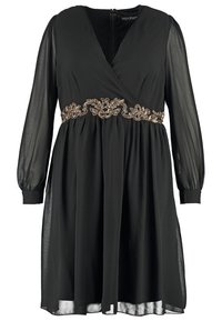 Czarna sukienka z zapinanym krojem, długimi przezroczystymi rękawami i dekoracyjnym pasem ozdobionym złotymi koralikami. Gładki materiał z płynącą sylwetką.