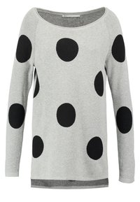 Světlé šedé svetr z pleteného materiálu s velkými černými puntíky, kulatým výstřihem a dlouhými rukávy. Horizontální spodní lem.