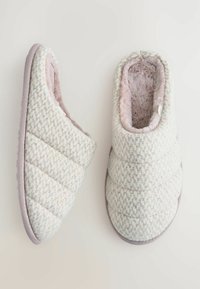 Pantofole trapuntate in tonalità pastello chiare con un interno morbido e peluche. Presentano una parte superiore texturizzata e una suola imbottita per il massimo comfort.