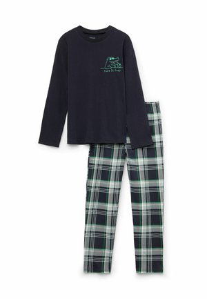 Schwarzes Langarmshirt mit Krokodil-Grafik und "Take it Easy" Text, kombiniert mit grün-weiß karierten Hosen.