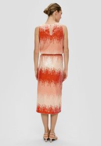 Paillettenjurk met een verlooppatroon van oranje naar perzik. Heeft een keyhole rug, een aansluitende taille en een rok tot de knie. Glad textuur.