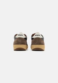 Sneaker in suede marrone con accenti in pelle nera a contrasto, colletto bianco cucito e suola in gomma testurizzata. Logo sul tallone.