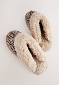 Leopardimustriga suss beige kunstkarusnahast voodriga. Pehme tekstuur ja ümar kuju; avatud kontsaga disain mugavaks jalga sisenemiseks.