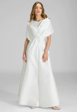 Witte satijnen jurk met een nauwsluitend lijfje, brede vierkante halslijn en een vloeiende rok. Heeft een gedrapeerde wikkel over de schouders.